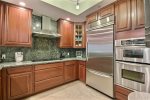 Full kitchen on 2nd level with wood cabinetry topped with gleaming granite, stainless appliances